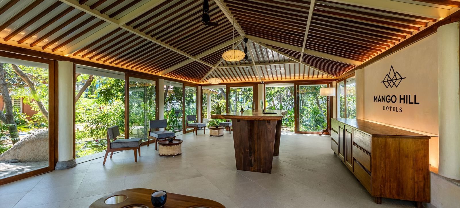 Open-air lounge area with comfortable seating and a high, intricately designed ceiling | Mango Hill Shallow Beach Resort ECR
