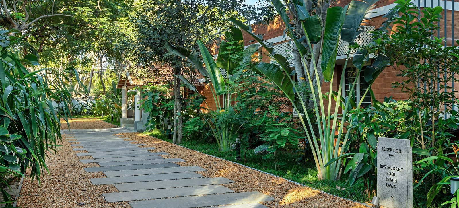 Path leading through lush greenery at a tropical resort | Mango Hill Shallow Beach Resort ECR