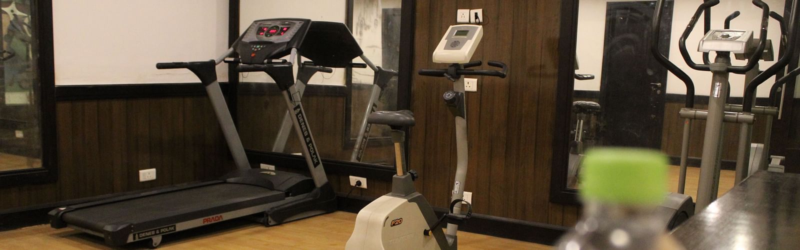 An image of a gym at Inde Hotel Vista Woods featuring treadmill , cardio machine, and other fitness quipment