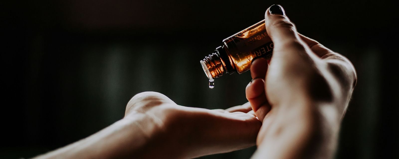 A person pouring essential oils on their hand