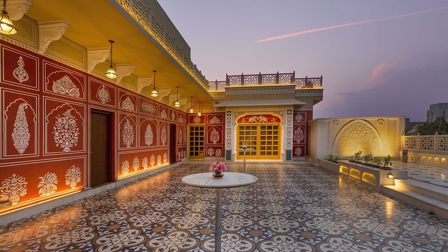 Ornate rooftop terrace with patterned tiles, decorated walls, and soft evening light - Heritage Village Resorts & Spa.