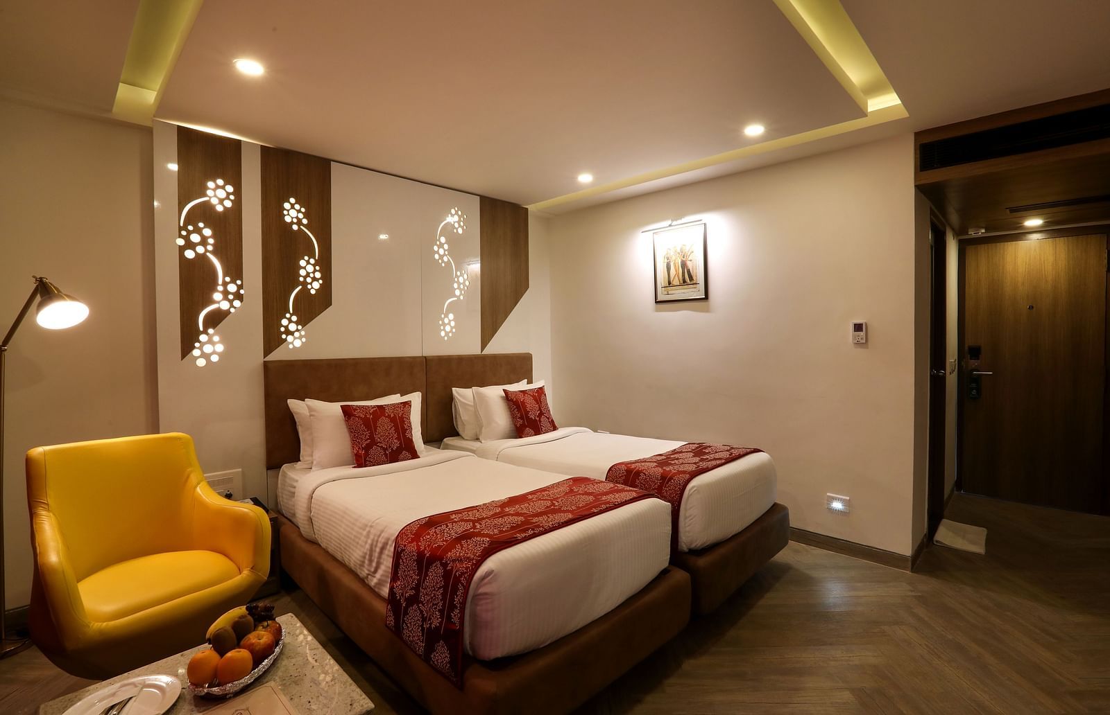 A bedroom with two single beds and a sofa and small table on one end beside the windows - Mango Hill Central, Chennai