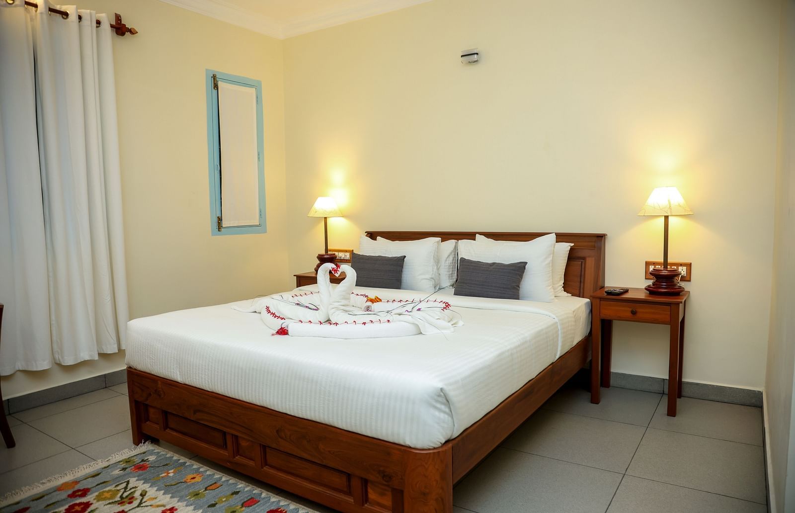 A bedroom which has a bed decorated by towel swans | Mango Hill La Serene, Pondicherry