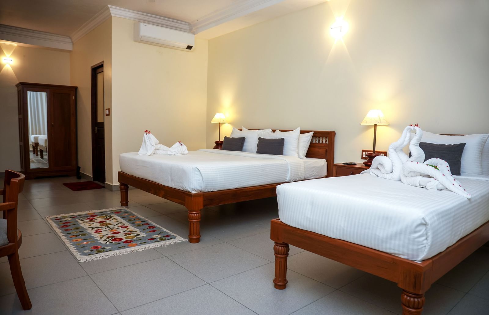 A large bedroom with two beds placed beside each other | Mango Hill La Serene, Pondicherry