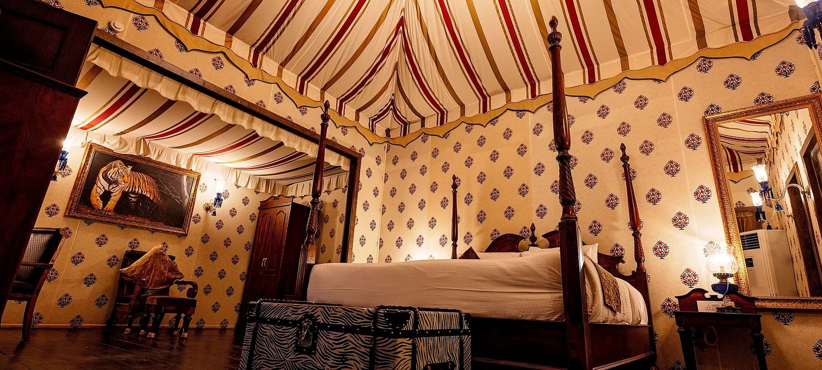 Image of a luxury tent with a bed and a mirror beside the bed Rajasthali Resort & Spa Jaipur.
