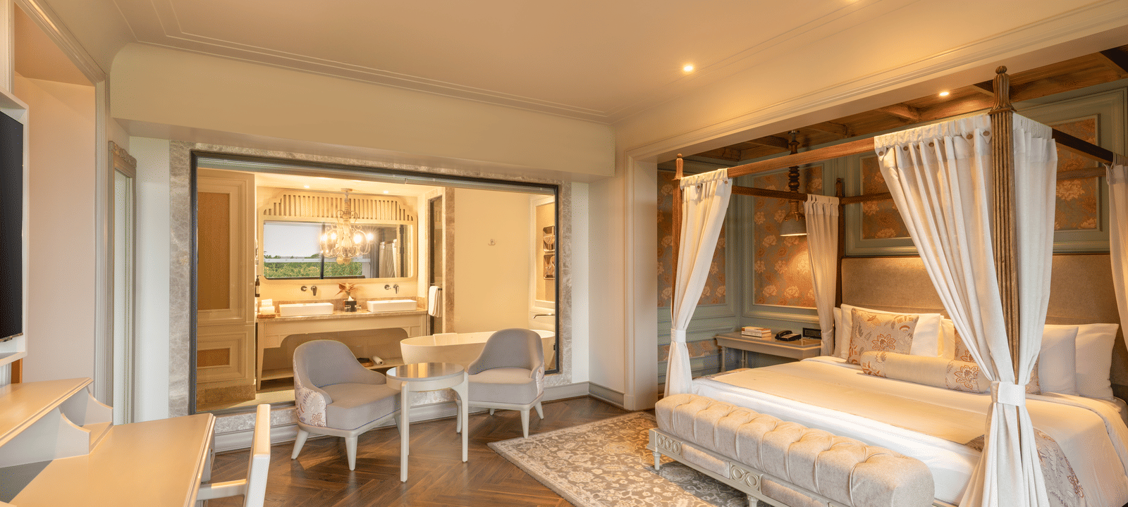 Side-view of the bedroom at the Evren Suite featuring a double bed along with a huge glass partition separating the bedroom with the bathroom at The Evren, Vagator.