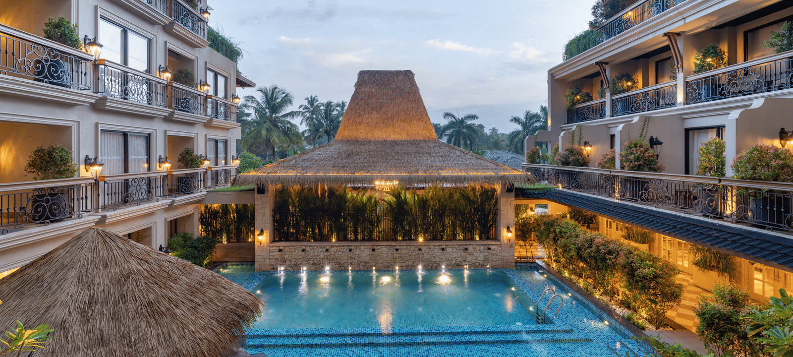 The swimming pool at The Evren, Vagator, between 2 building complexes during the early evening hours.