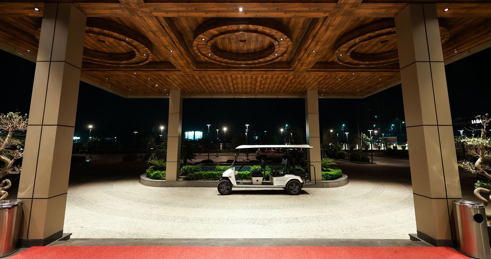 Night view of Ramada by Wyndham Sonipat Murthal entrance with red carpet and decorative ceiling