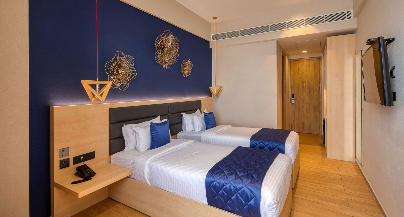 Twin beds with blue bedsheets and pillow covers at Executive Room at Le Foliage by TGI, Bangalore 2