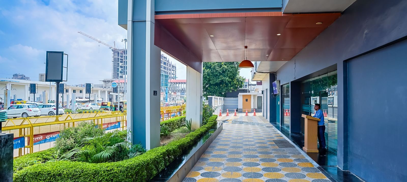 Entrance walkway with patterned tiles and greenery at Max Hotel Prayagraj.