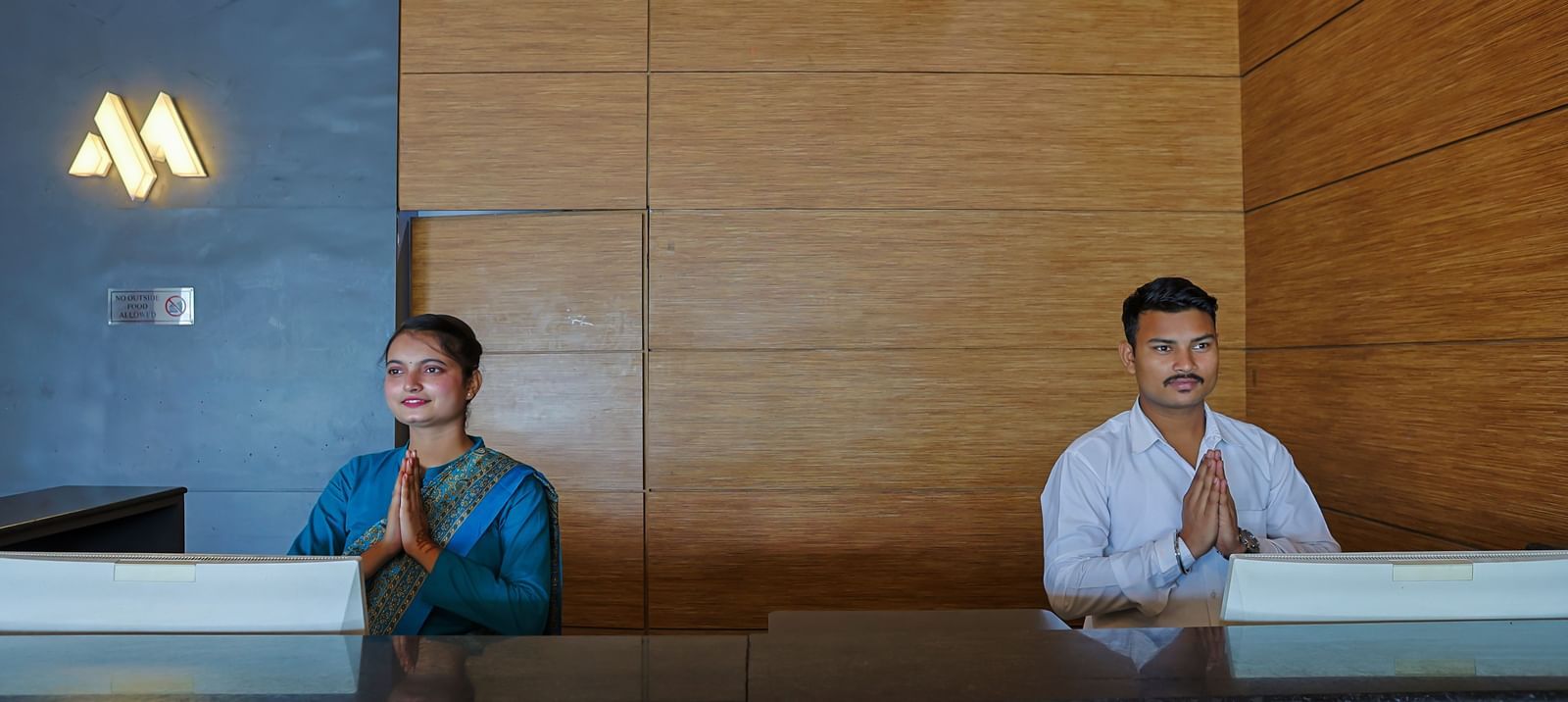 Reception desk with staff members at Max Hotel Prayagraj.