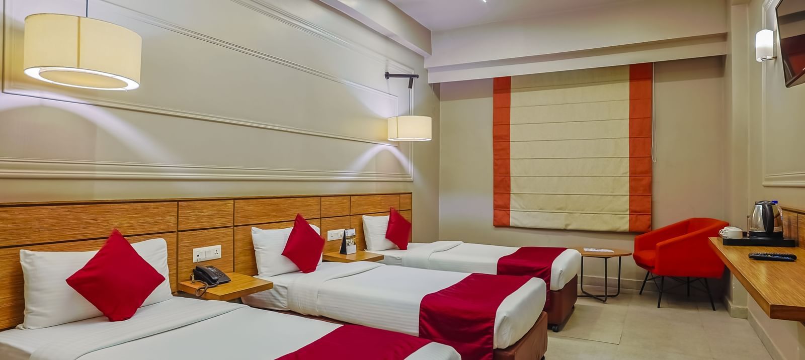 Spacious room with three single beds and modern design at Max Hotel Prayagraj.