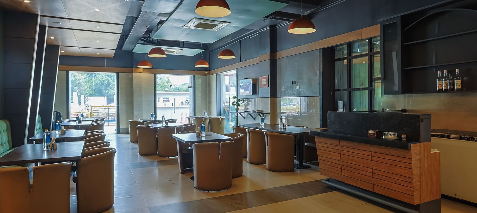 Spacious restaurant with tables, chairs and large windows at Max Hotel Prayagraj.