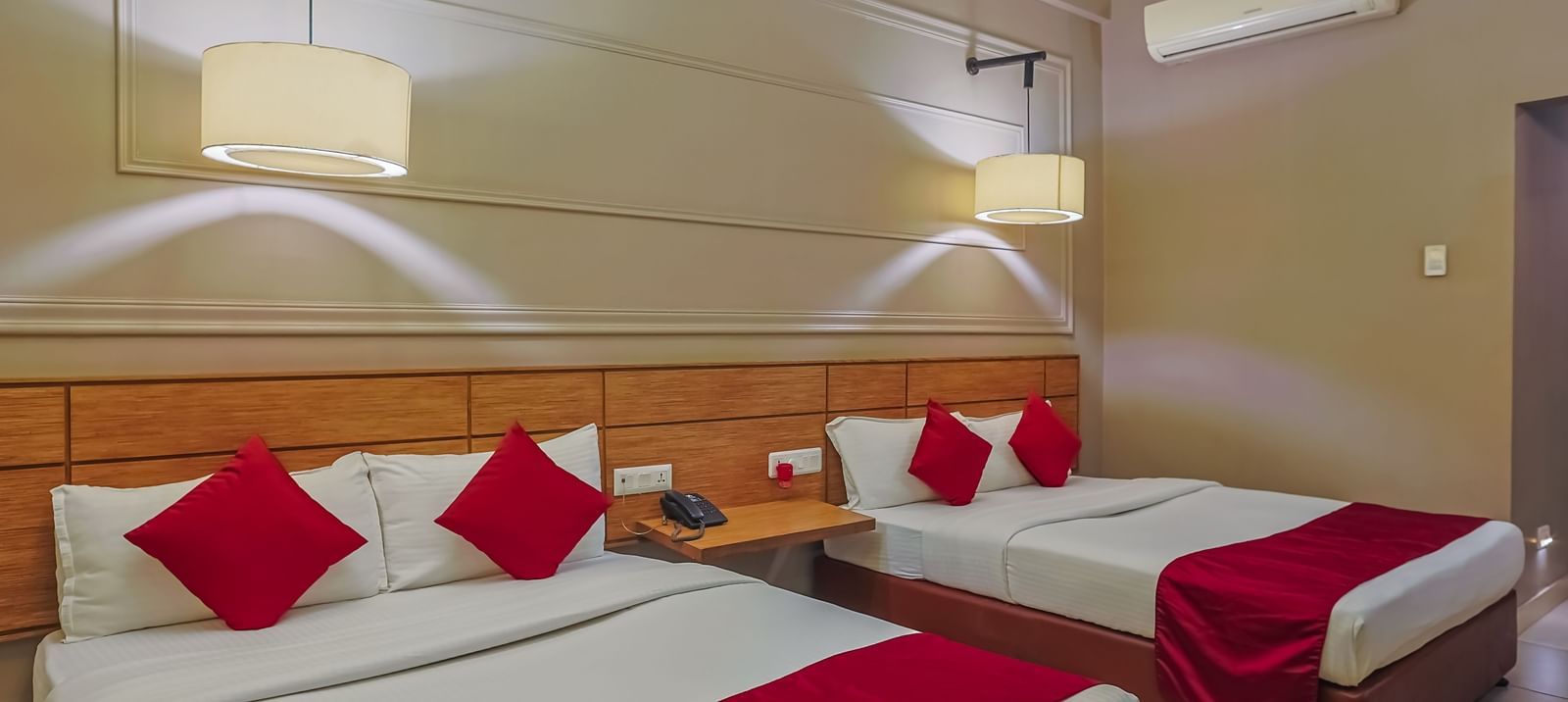 Neat hotel room with twin beds and wall decor at Max Hotel Prayagraj.