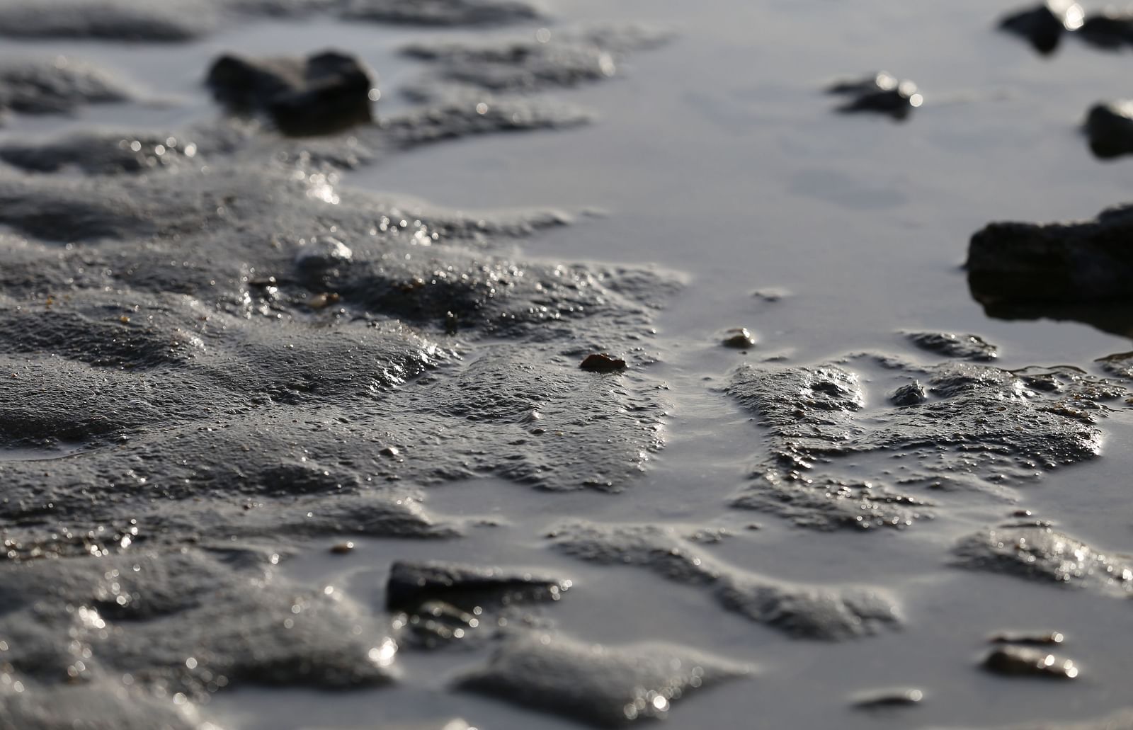 An overview of a muddy place with some waterbody on top of it.