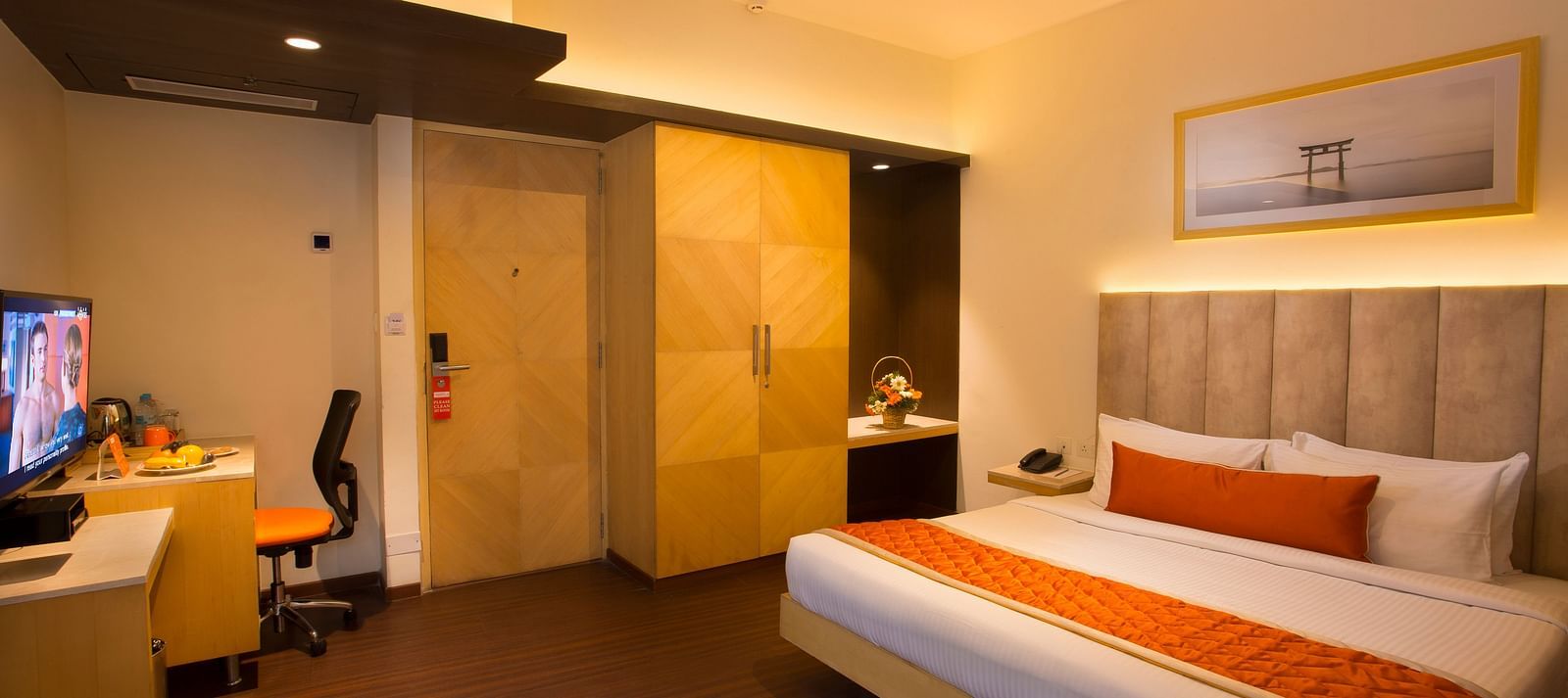 A spacious hotel room with a comfortable bed, ambient lighting and a television, featuring a wooden wardrobe and desk - Hotel Langford Keys by TGI, Shanti Nagar