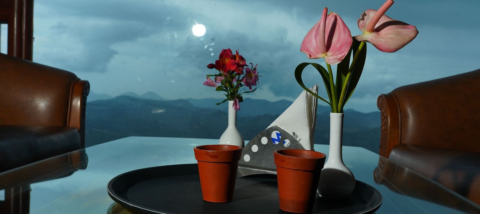 two cups of tea placed on a table along with flowers and napkins at La Montana By TGI, Ooty