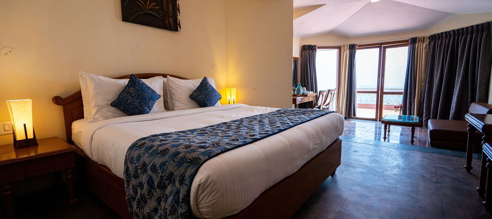 comfy bed with blue duvet and pillows at La Montana By TGI, Ooty
