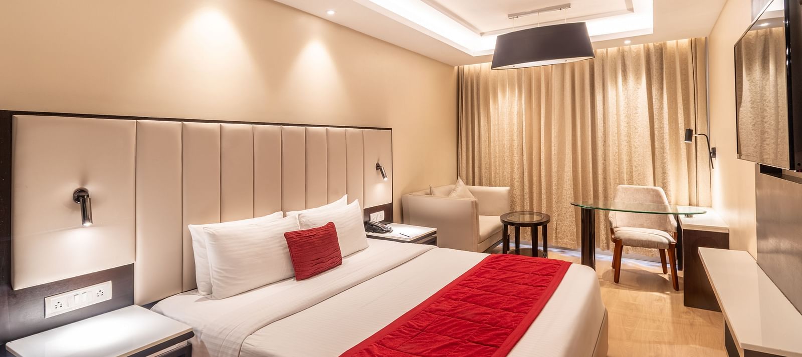 Grand Suite with a huge bed, red accents, and soft ambient lighting,- TGI Grand Fortuna, Krishnagiri Main Road, Hosur
