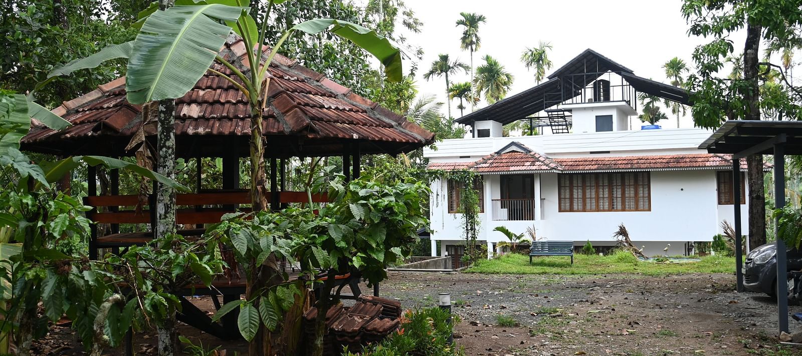 View of the Facade of Ananda Holiday Home in Wayanad along with a gazebo outside between the greens