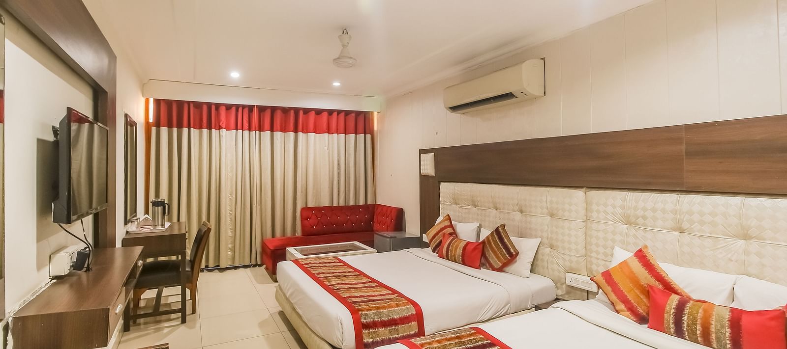 Family Room featuring a work desk, large window with curtains, and two queen sizebeds -  Hotel Diamond Plaza, Chandigarh.