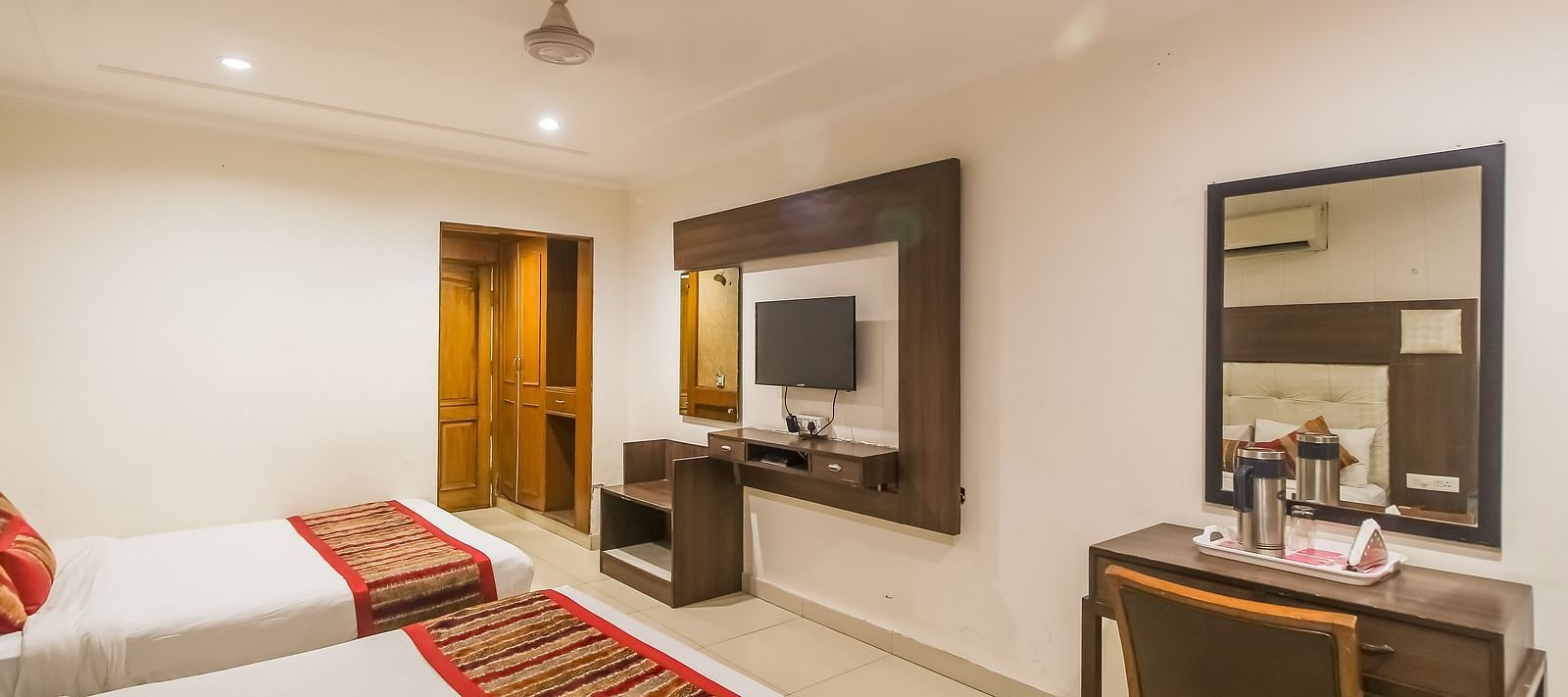 Well-lit Family Room with two queen size beds, wooden accents, and contemporary furnishings - Hotel Diamond Plaza, Chandigarh.