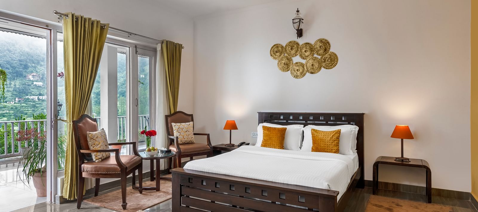 Spacious bedroom with large bed, seating area, and balcony access, at BluSalzz Collection - Suvaasa Resort, Ramgarh.
