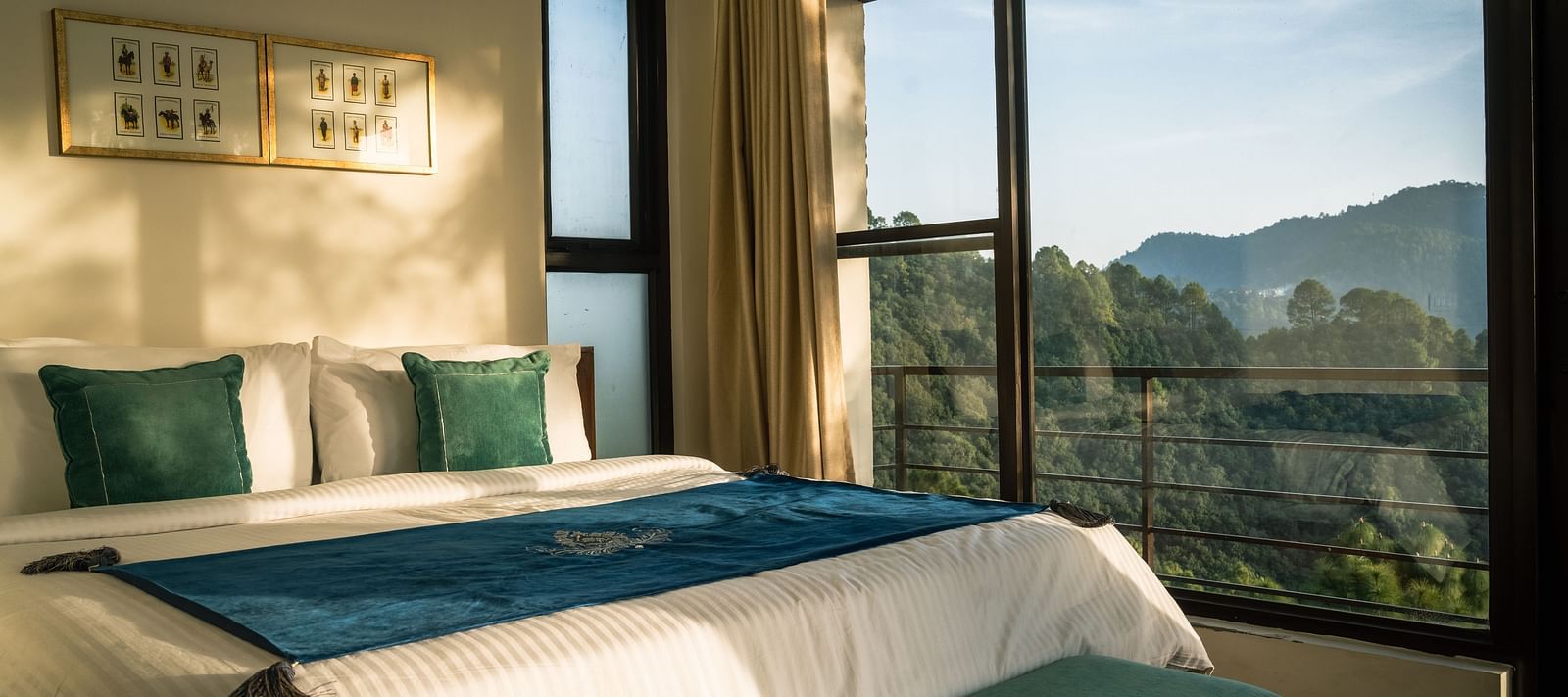 A bedroom with a balcony offering a mountain view and sunlight streaming in at BluSalzz Escapade Resort, Lansdowne