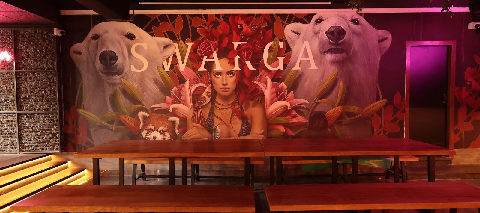 A large wooden table with seating in front of a postered wall | Cenneys Gateway