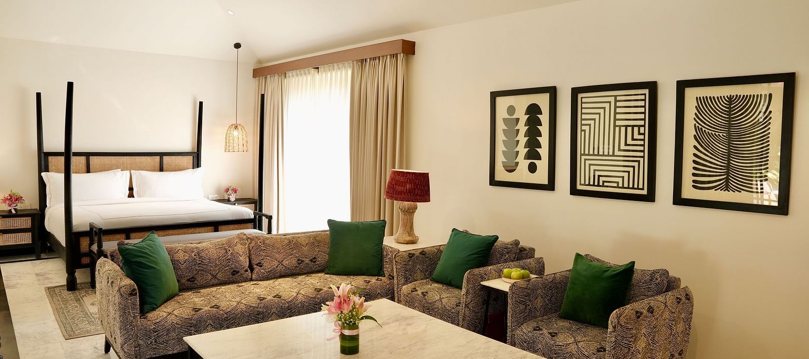 A room with a bed and a seating area adorned with frames at Surpura Bagh.