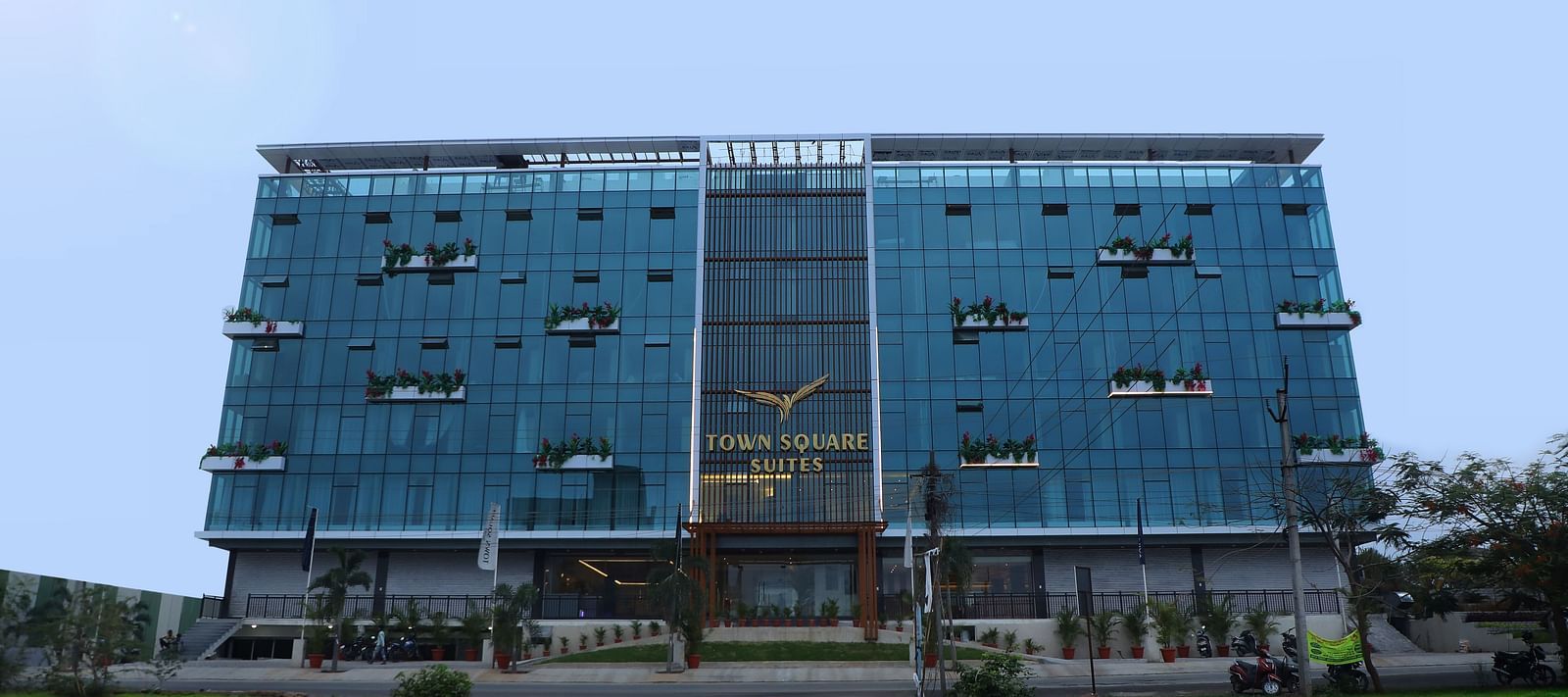 Exterior view of Town Square Suites showing modern architectural design and lush green lawn