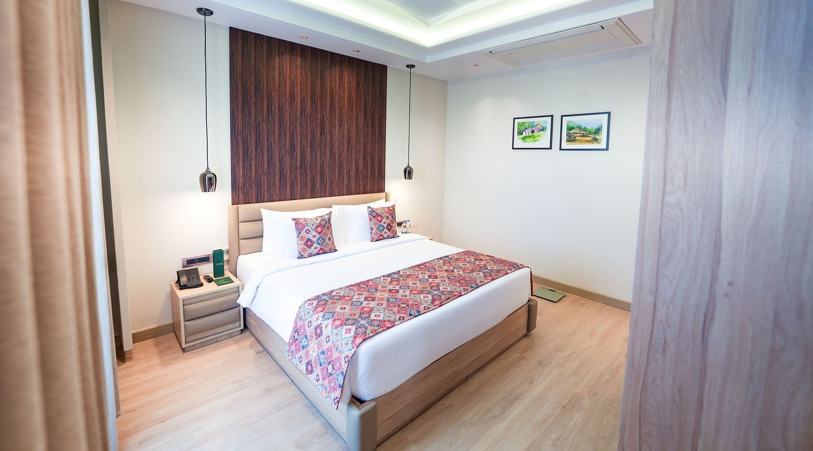 An image of a bed with a nightstand beside it, featuring hanging ceiling lamps that create a coy, warm lighting in the room - NAMAMI BY ZENQ BANKHANDI