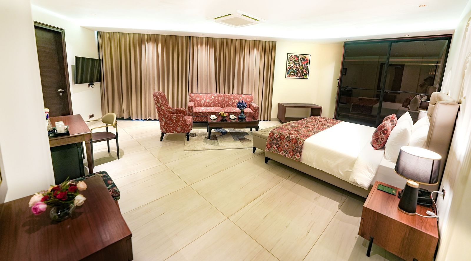 An image showcasing the expansive suite, complete with cosy furniture and a plush queen size bed - NAMAMI BY ZENQ BANKHANDI