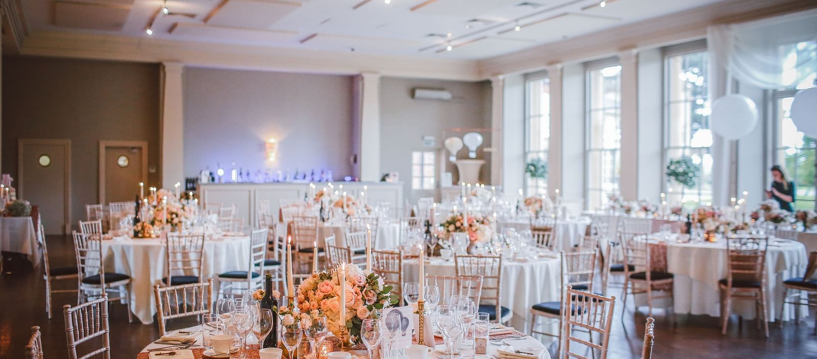 An elaborate banquet hall with round table seating and sun shining through the floor to ceiling windows | Mango Hill Shola, Ooty