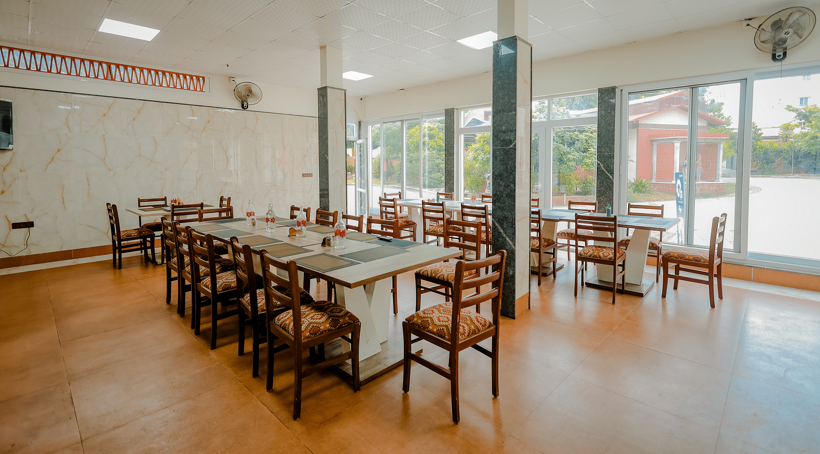 A dining area or event space with long tables and chairs at Nirantara Resort & Spa.