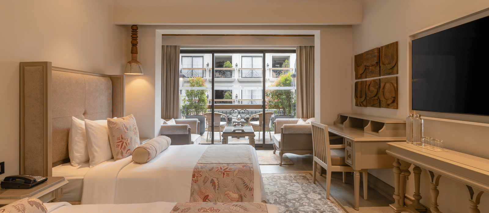 Side view of the Premium Room with a twin bed featuring wide french windows at the far end of the room at The Evren, Vagator.