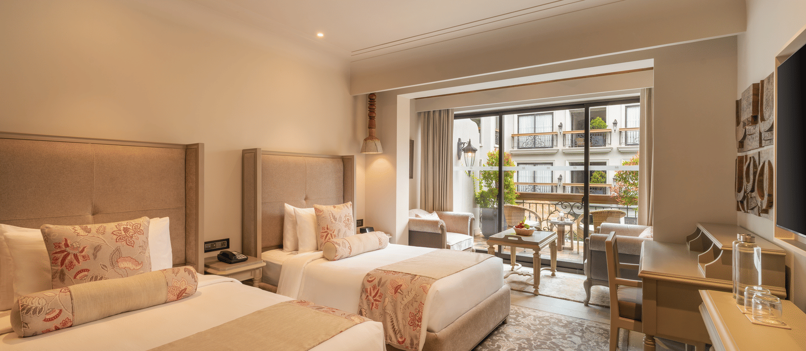 Corner view of the Premium Room with with beds at The Evren, Vagator, with ample of natural light coming from the french windows.