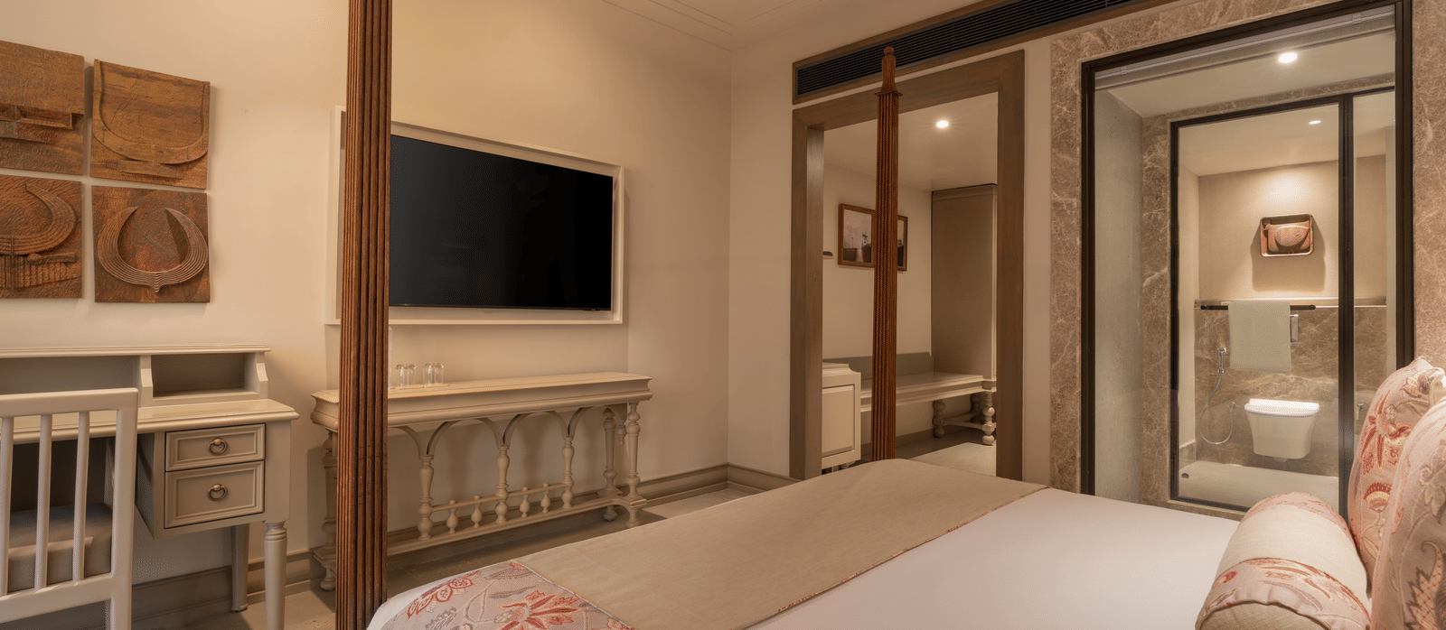 A corner view of the Claasic Room (Diwa) featuring a double bed along with a wall-mounted television in front of it at The Evren, Vagator.