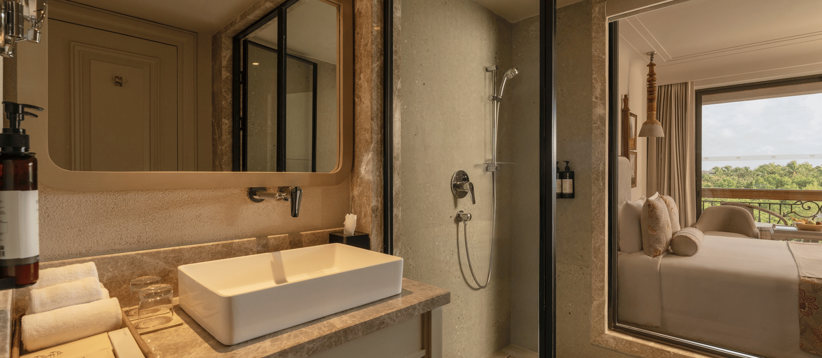 A neatly-kept vanity area with a rectangular mirror above it at the Classic Room (Diwa), seaprated by a glass partition at The Evren, Vagator.