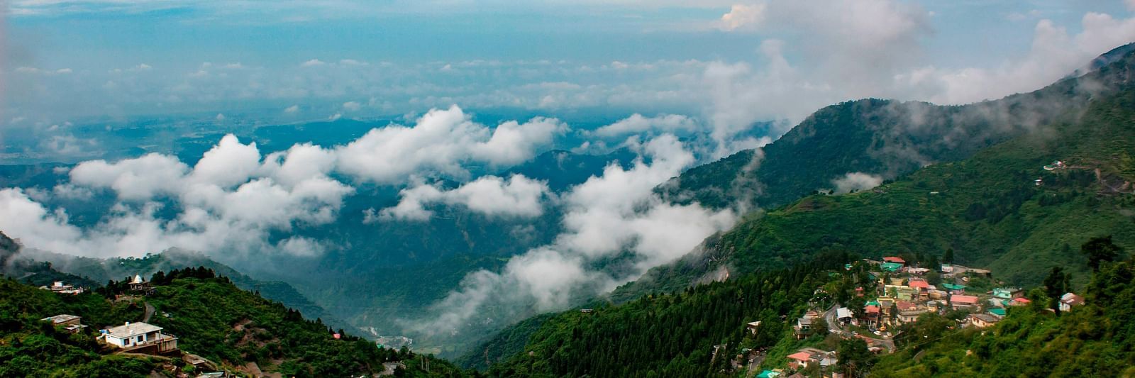 a serene landscape of mussoorie with clouds in the sky