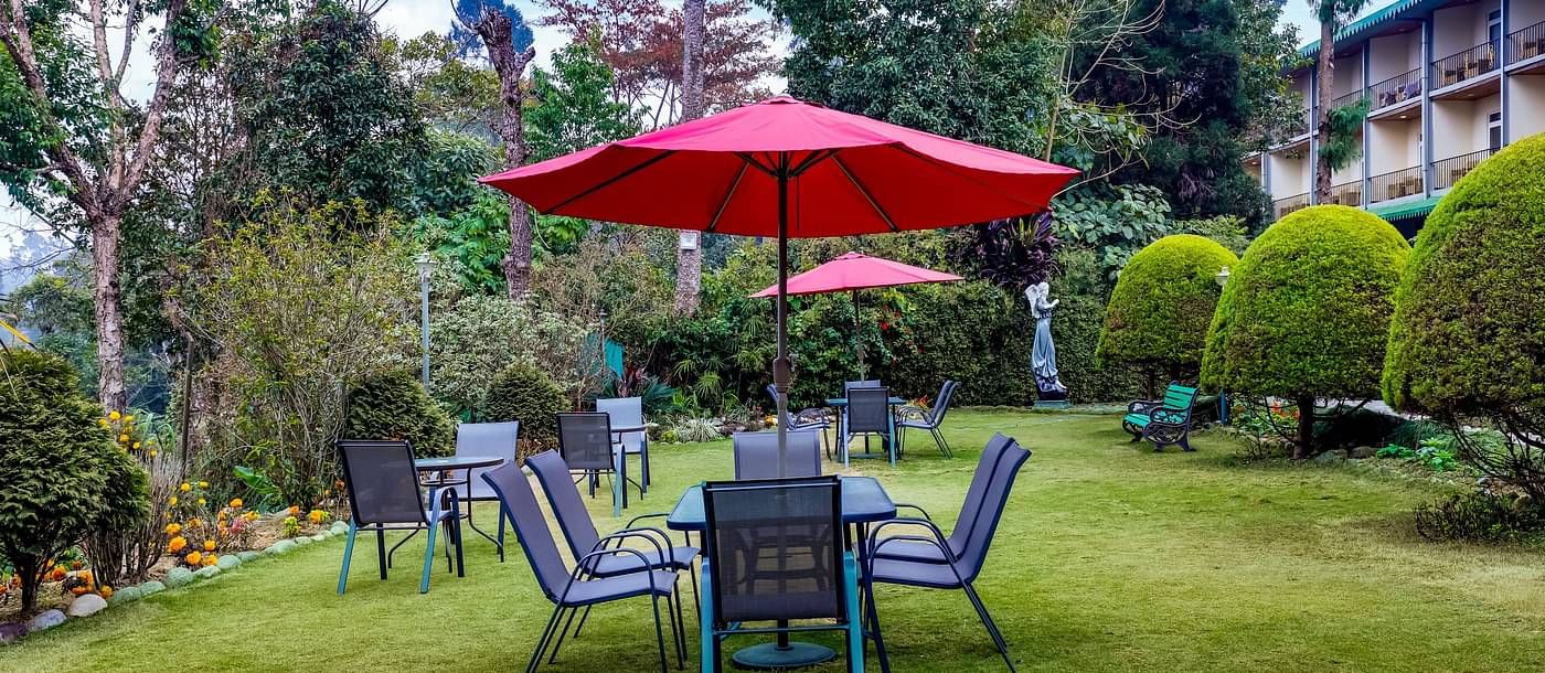 image of a sitting area in a lush green lawn at summit barsana resort and spa in kalimpong