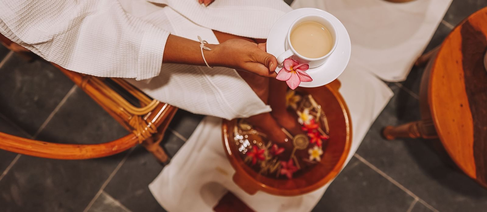 A person enjoying a relaxing spa treatment with a cup of tea - Alibu Resort Nha Trang