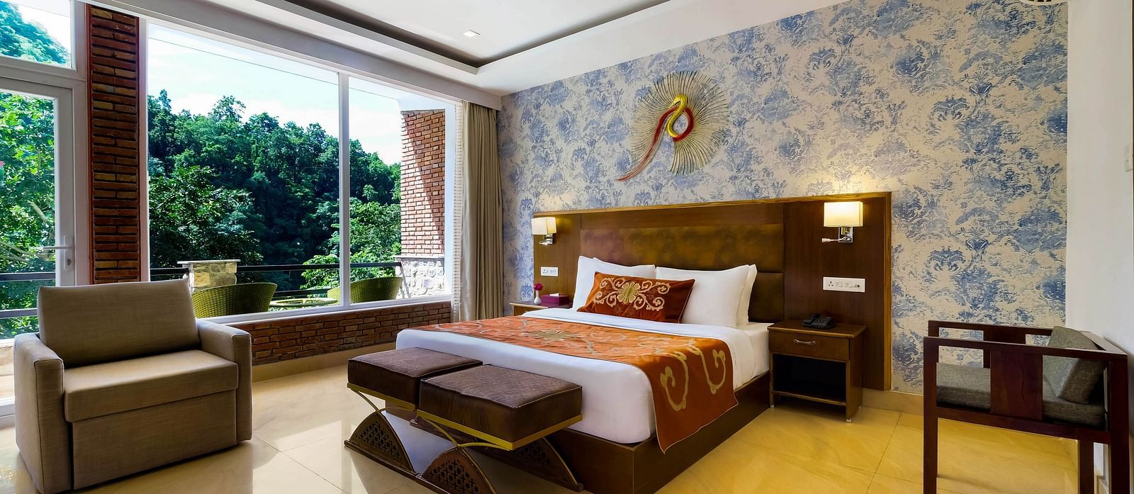 Side view of a room with bed and sitting area with large windows at Summit By The Ganges Beach Resort & Spa, Rishikesh