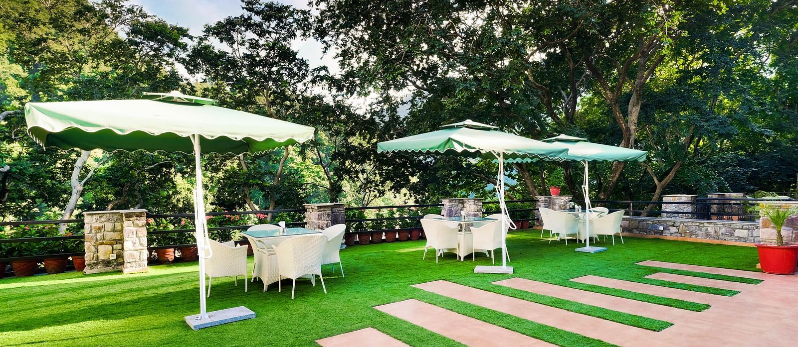 Outdoor seating area with umbrellas at Summit By The Ganges Beach Resort & Spa, Rishikesh