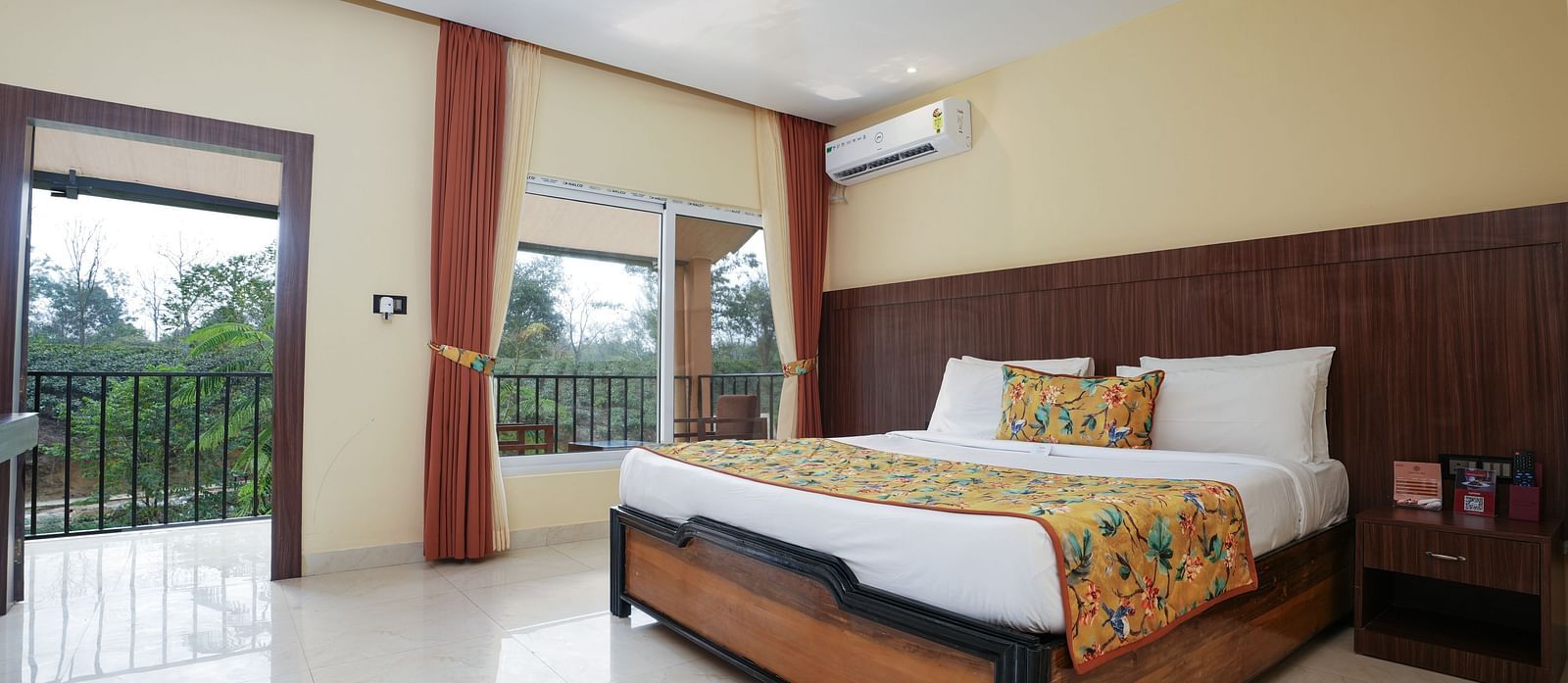 Premium room with balcony offering a nature view and spacious bed at Summit Green Lake Tea Resort & Spa, Kaziranga