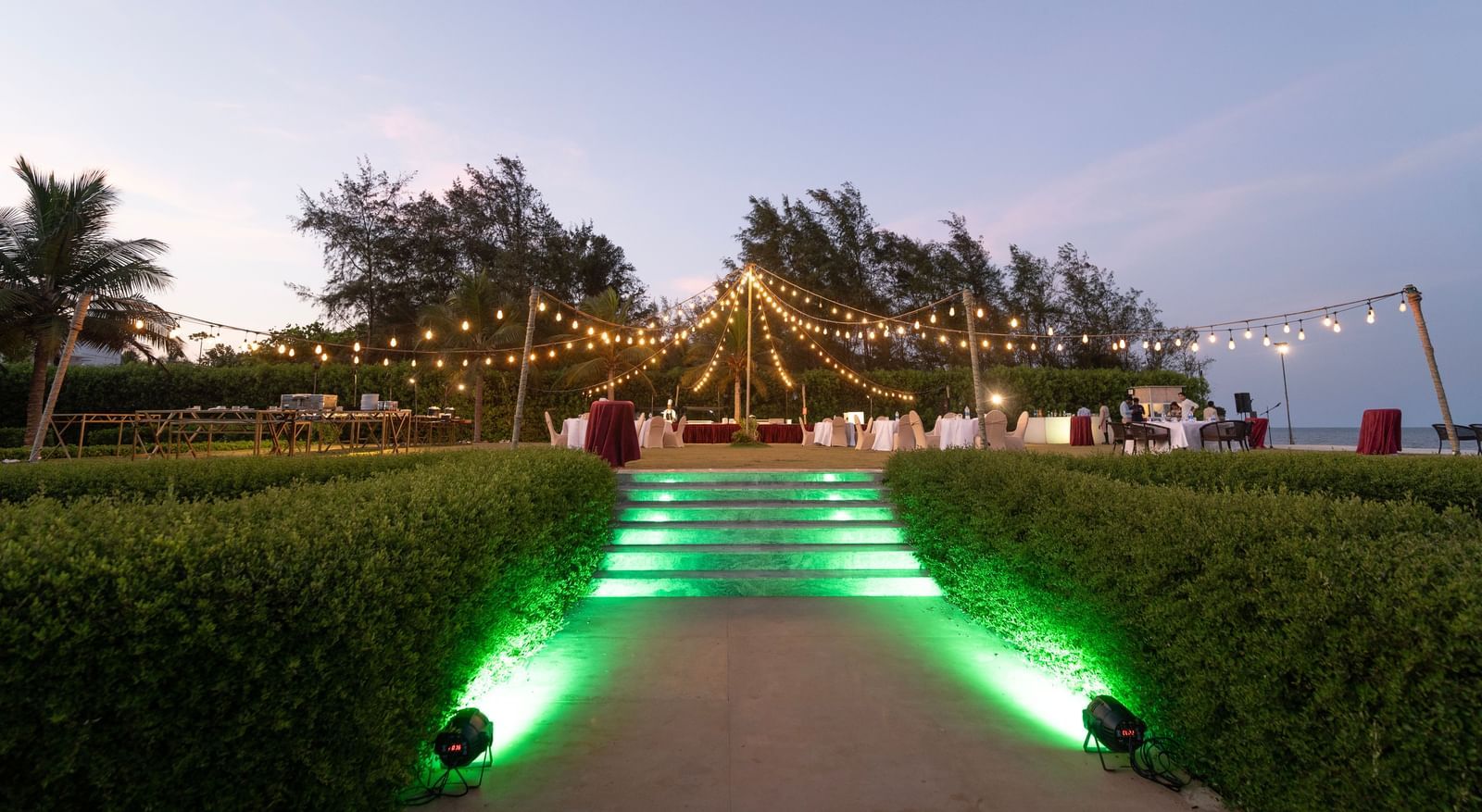 Garden pathway illuminated with green lights leading to an event area - Kaldan Samudra Palace