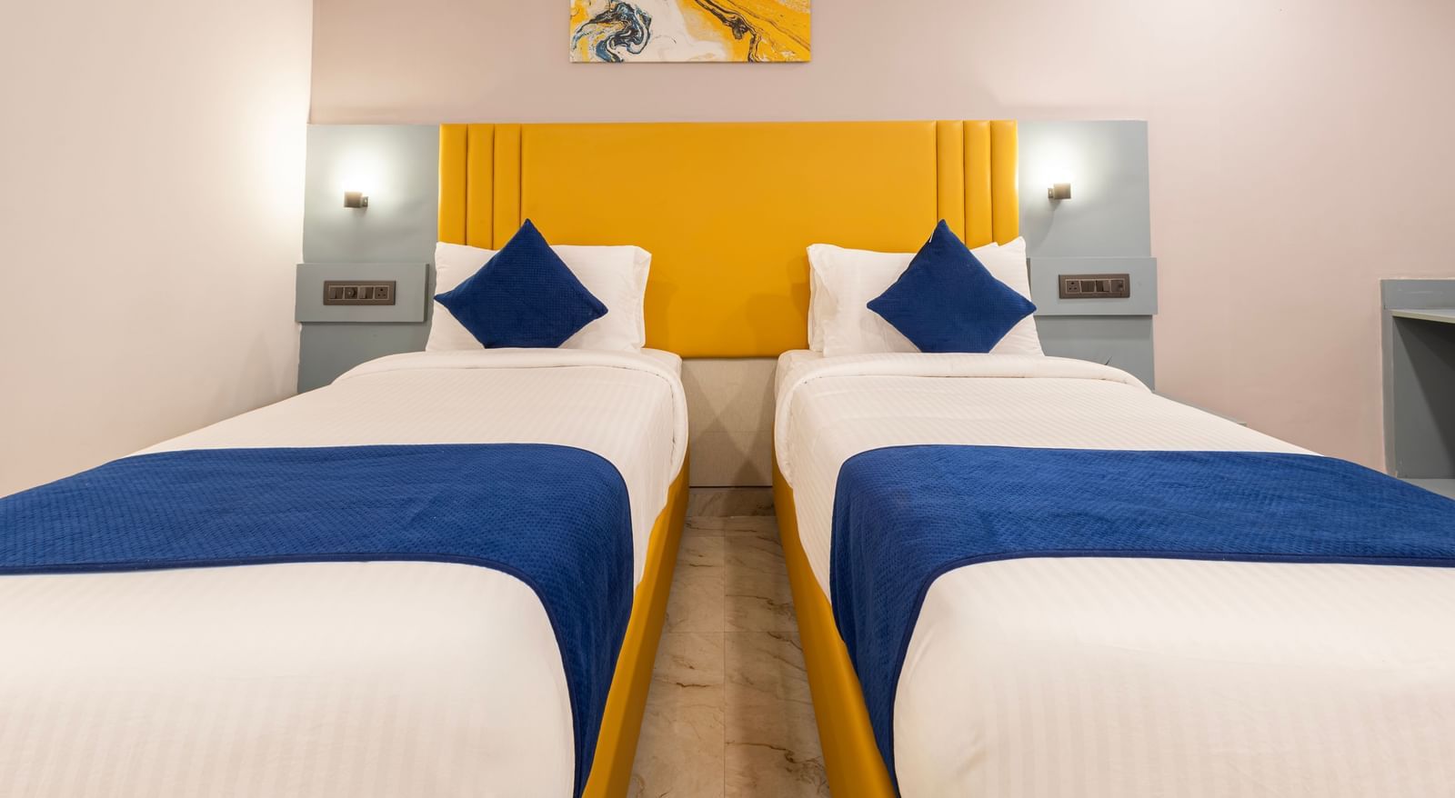 Close up of Superior Room featuring a bed with blue and white bedding, a yellow headboard, and modern furnishings including a desk and TV - Beestay Hotel Financial District, Hyderabad