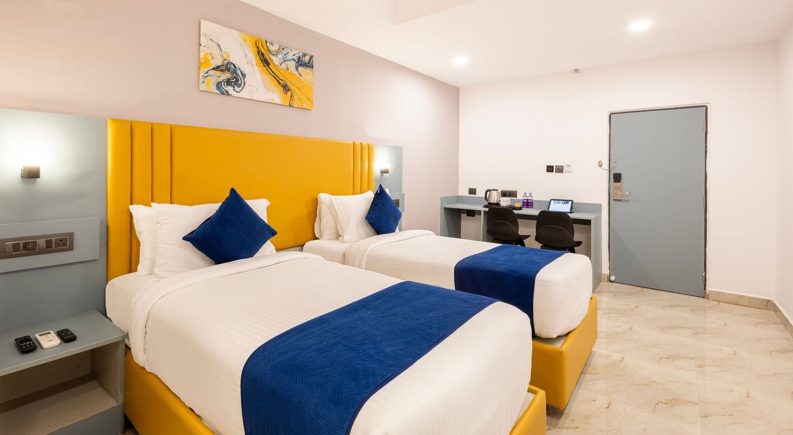 Full view of Superior Room featuring a bed with blue and white bedding, a yellow headboard, and modern furnishings including a desk and TV - Beestay Hotel Financial District, Hyderabad