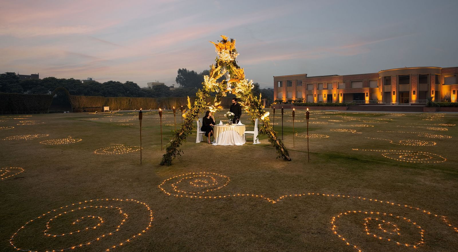  A couple enjoying dinner in an open-air setting at Nirvana Luxury Hotel, Ludhiana.