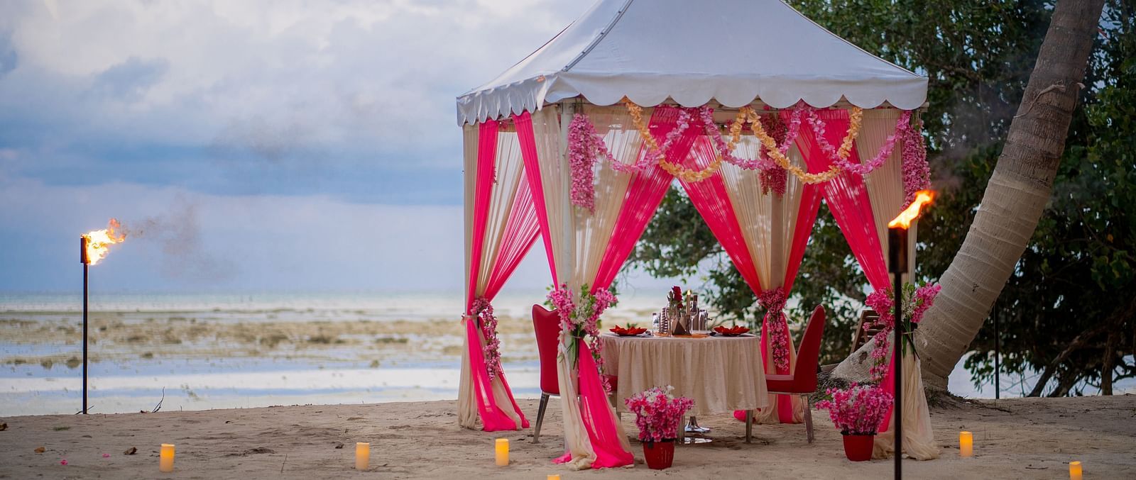 View of romantic dinner setup by the beach  at Coral Reef Hotel & Resort